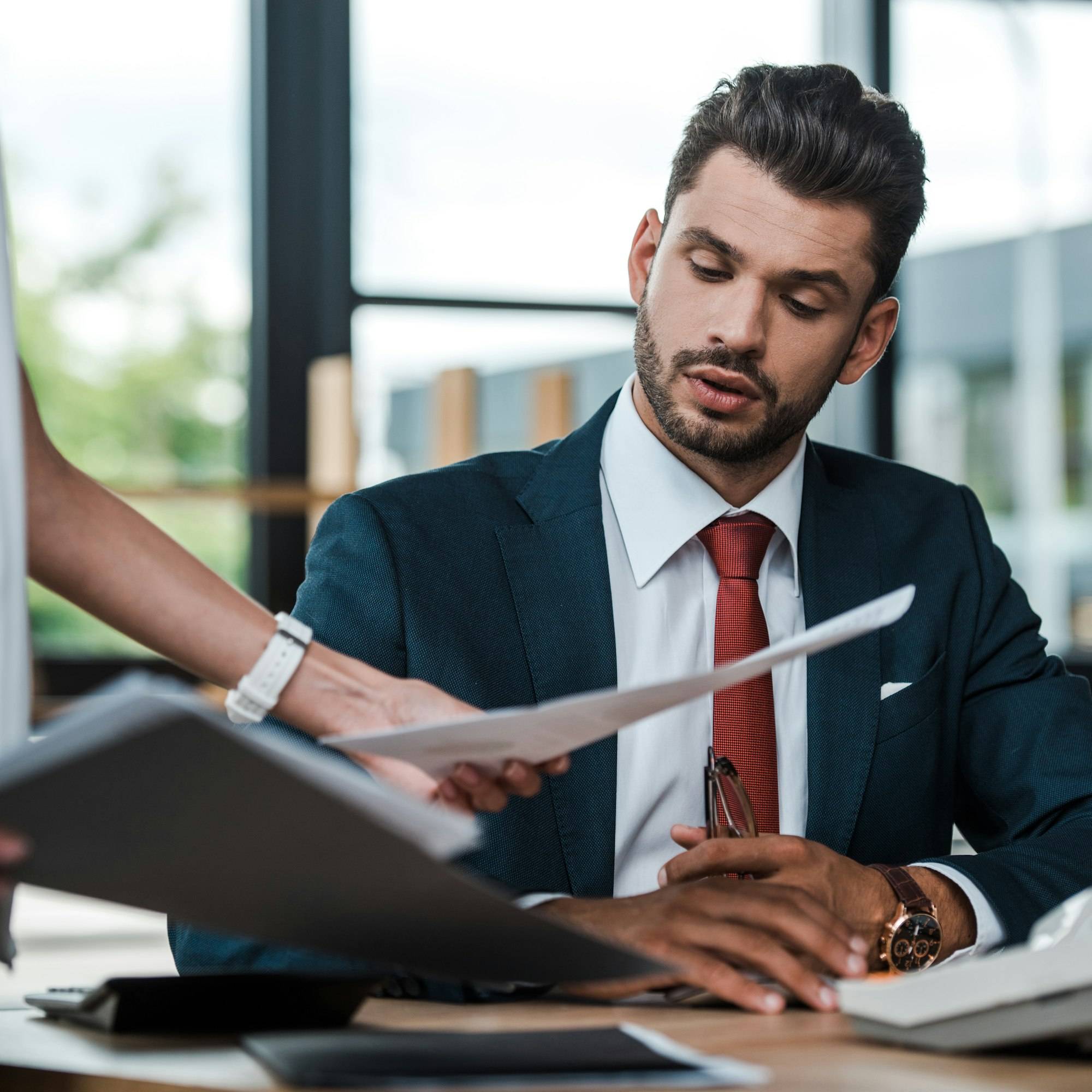 cropped view of woman holding folder and documents near bearded man